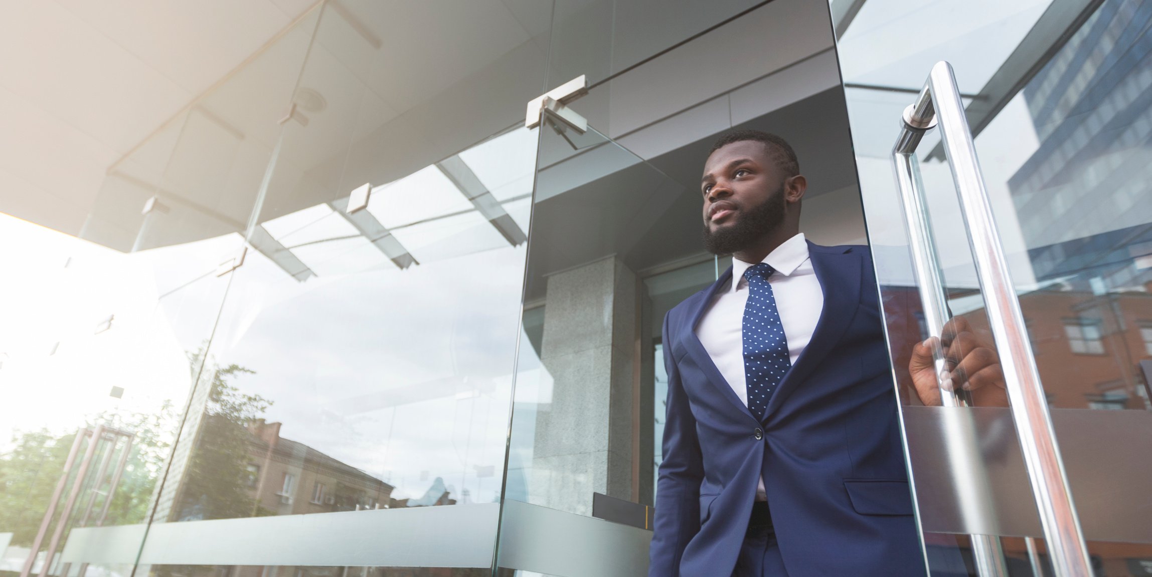 Young african job seeker leaving building after interview